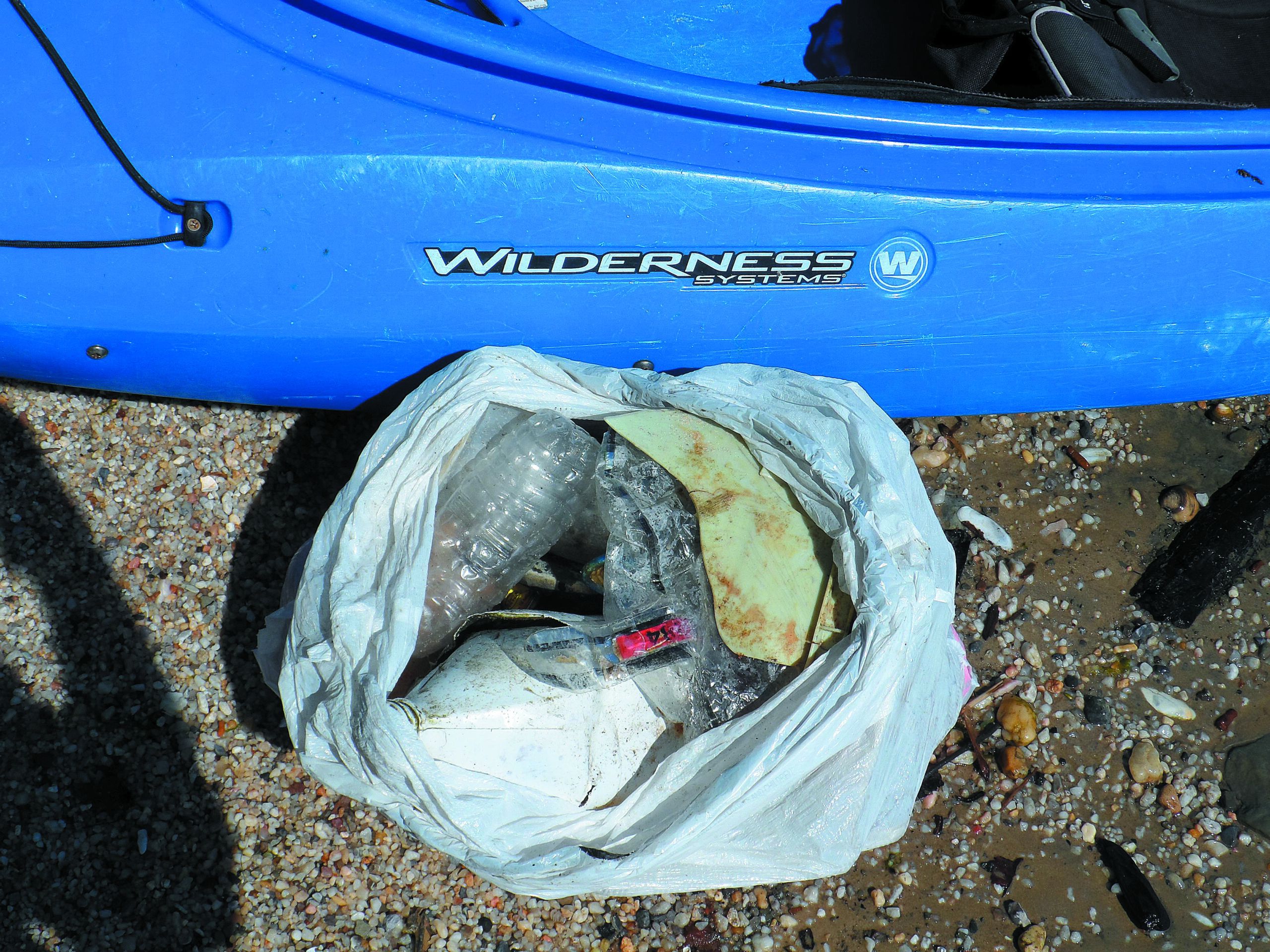 Garbage bags. Blue plastic garbage bags full of trash on the beach